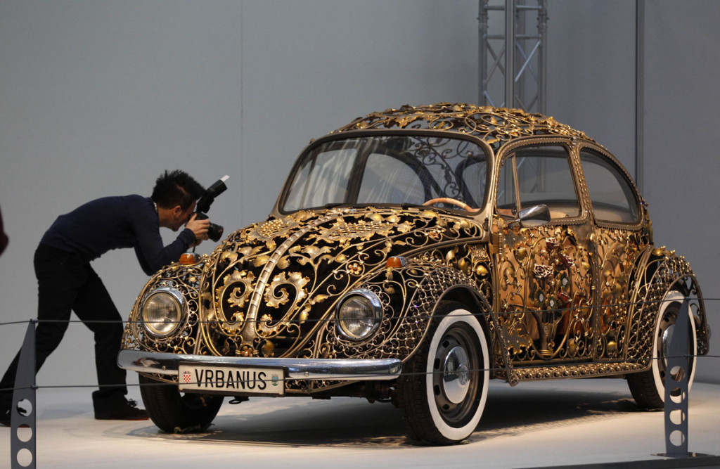 A visitor takes a picture at a modified Volkswagen VW Beetle during a press presentation prior to the Essen Motor Show in Essen